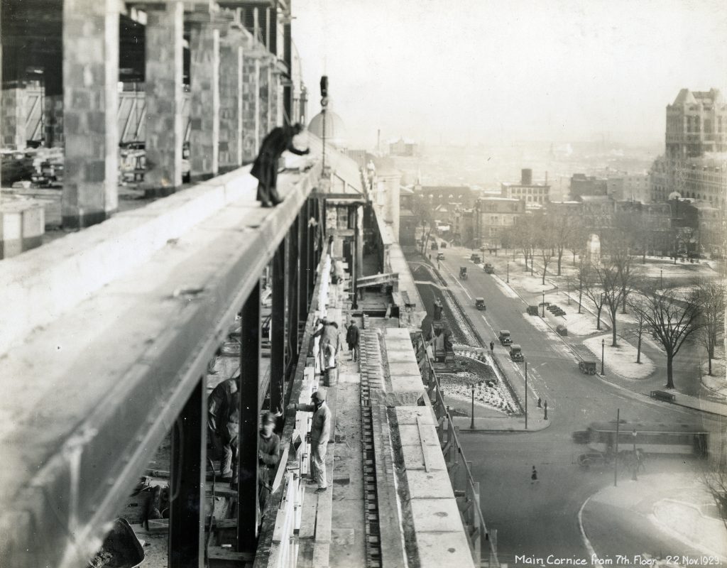 Des ouvriers travaillant sur la corniche principale située au 7e étage, le 22 novembre 1929.